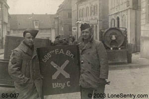 [GIs with sign for 608th FA Bn, Battery C]